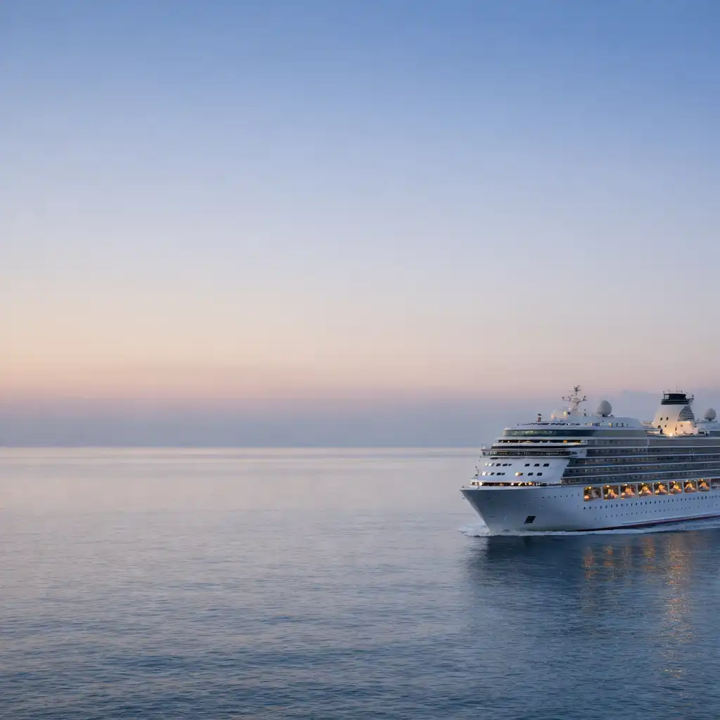 A contemporary white cruise ship travelling across calm water at dawn
